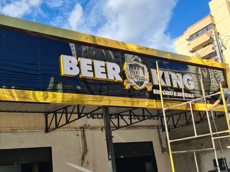 Painel preto e amarelo Beer King com estrutura de instalação visível.