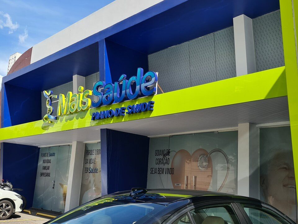 Fachada comercial com painéis azuis e verdes e identificação Mais Saúde.