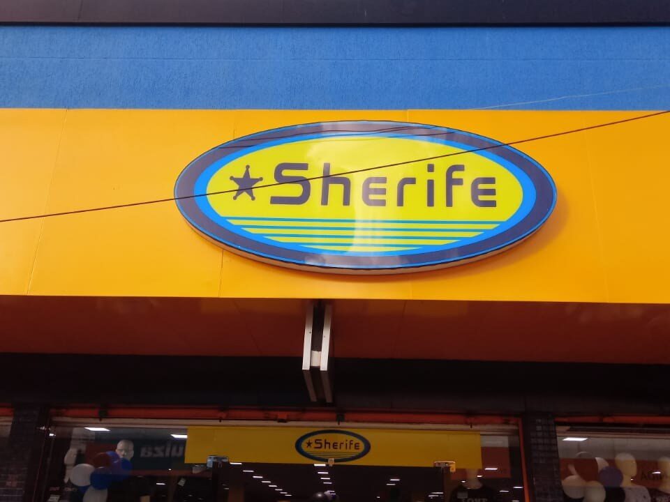 Fachada com painel amarelo e marca Sherife em destaque.