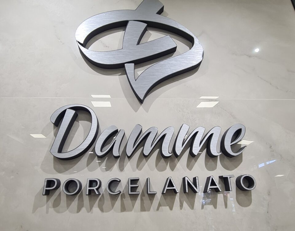 Identificação Damuê Porcelanato em alto relevo sobre parede clara.