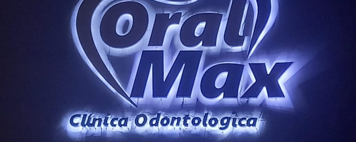 Logomarca Oral Max com halo branco sobre fundo escuro.